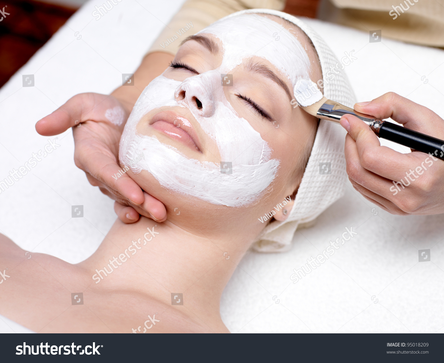 Beautiful woman with facial mask at beauty salon #95018209