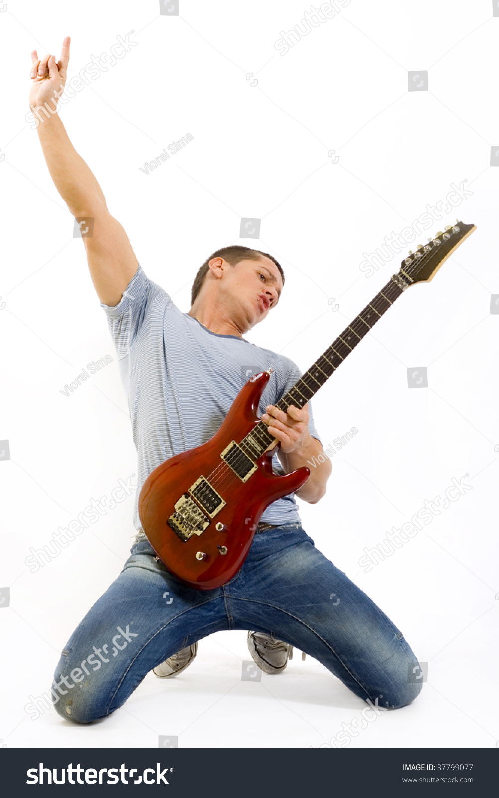 Passionate Guitarist Playing His Electric Guitar On His Knees Making A ...