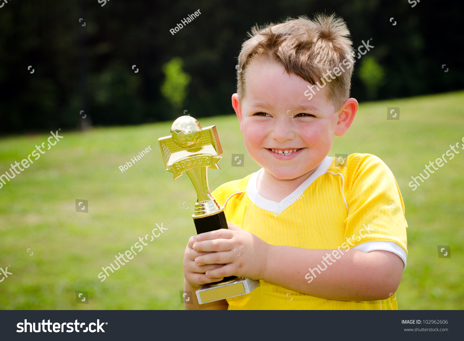 年轻的足球运动员穿制服,他的新奖杯 - 人物,运