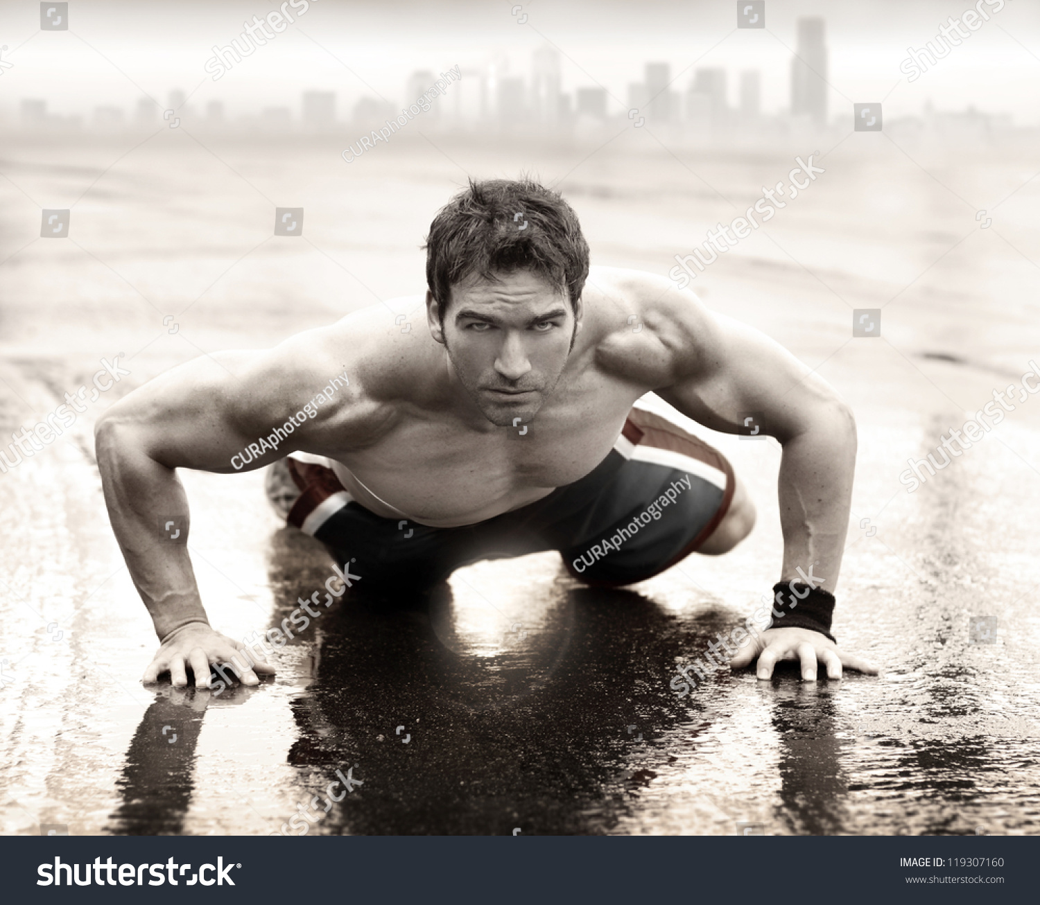 性感适合肌肉男人做俯卧撑湿路上背景与城市天