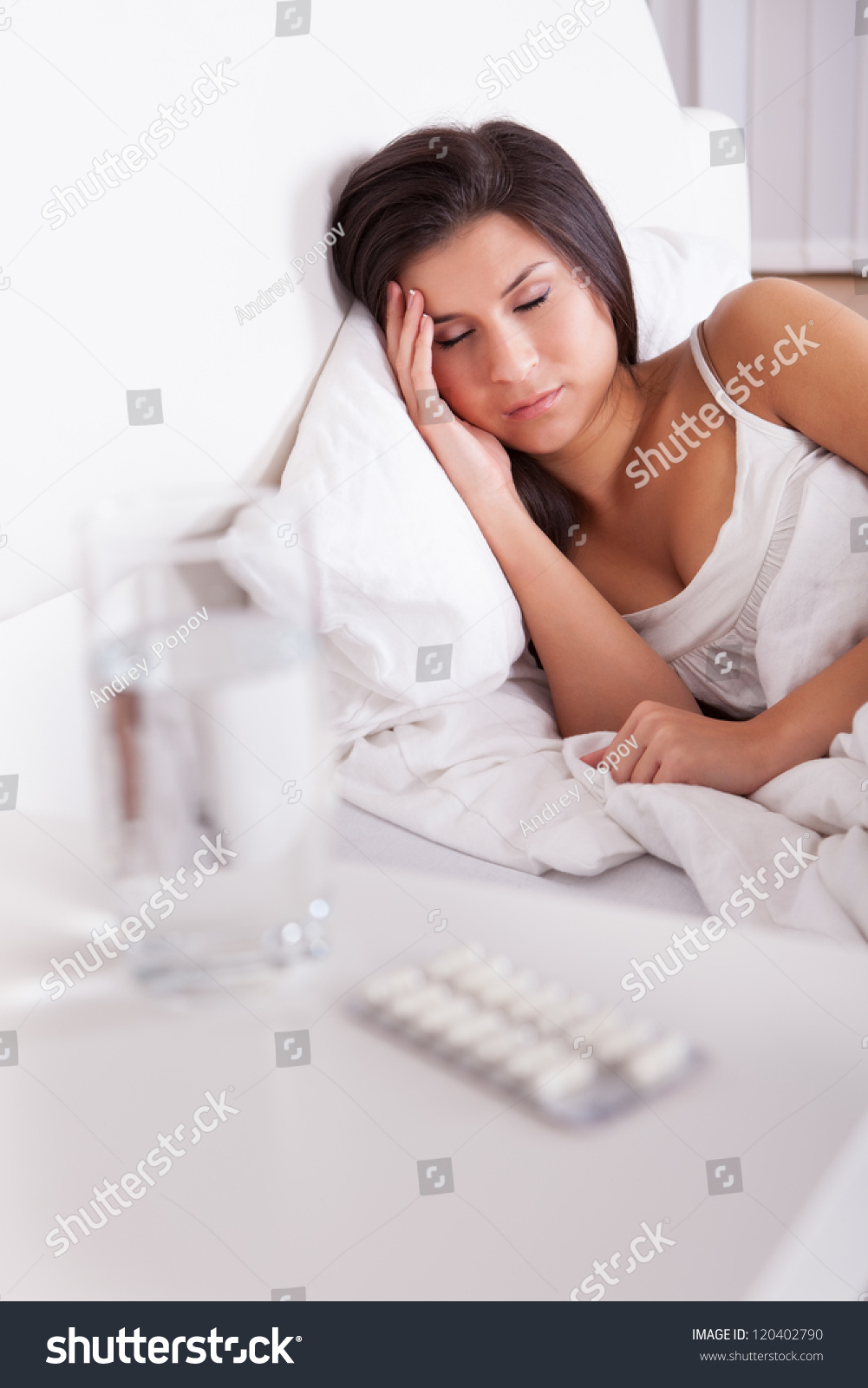 生病的女人睡在床上支撑对她枕头的模糊的玻璃