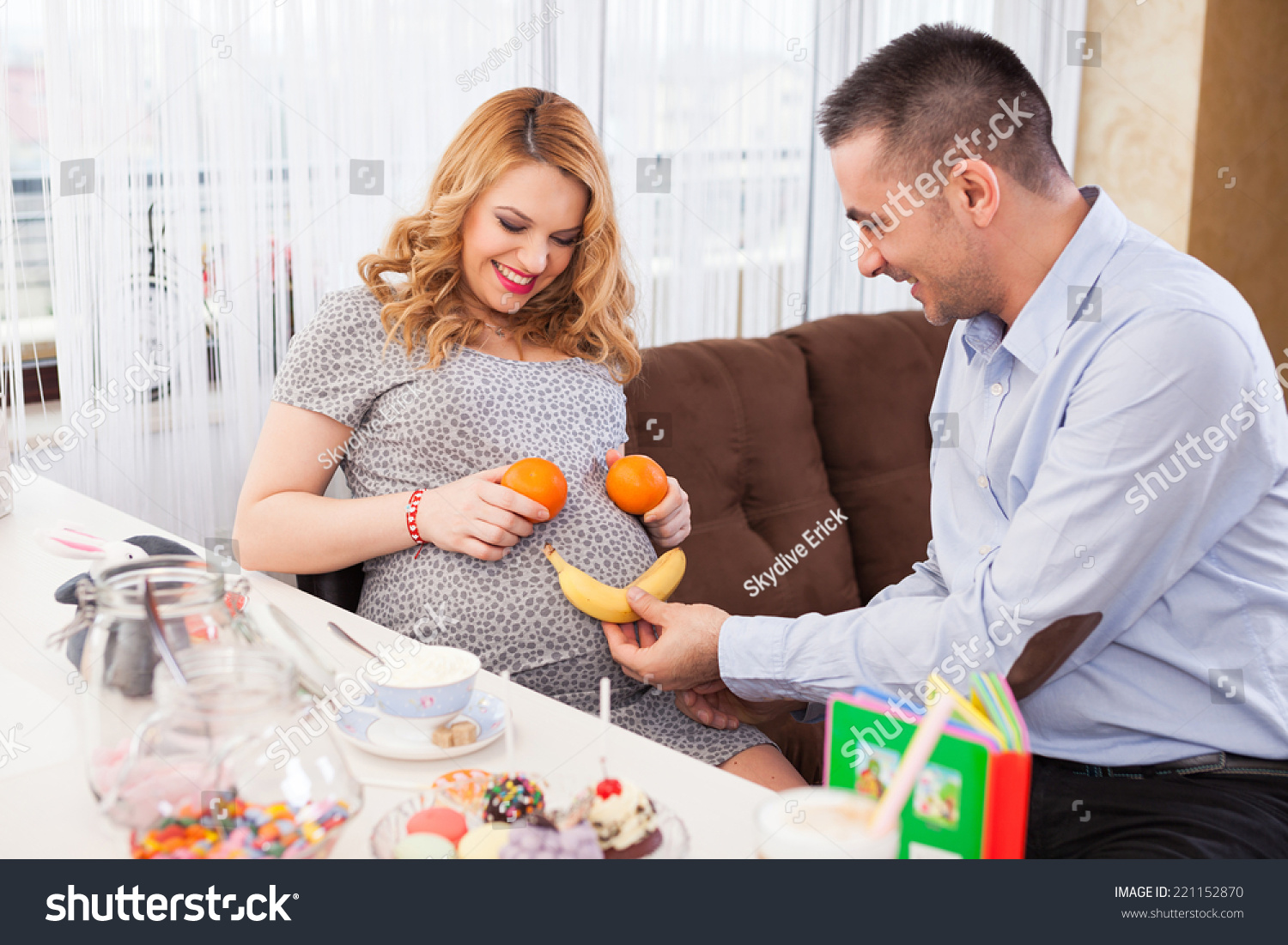 一个年轻的孕妇和她的丈夫的照片让微笑在她的