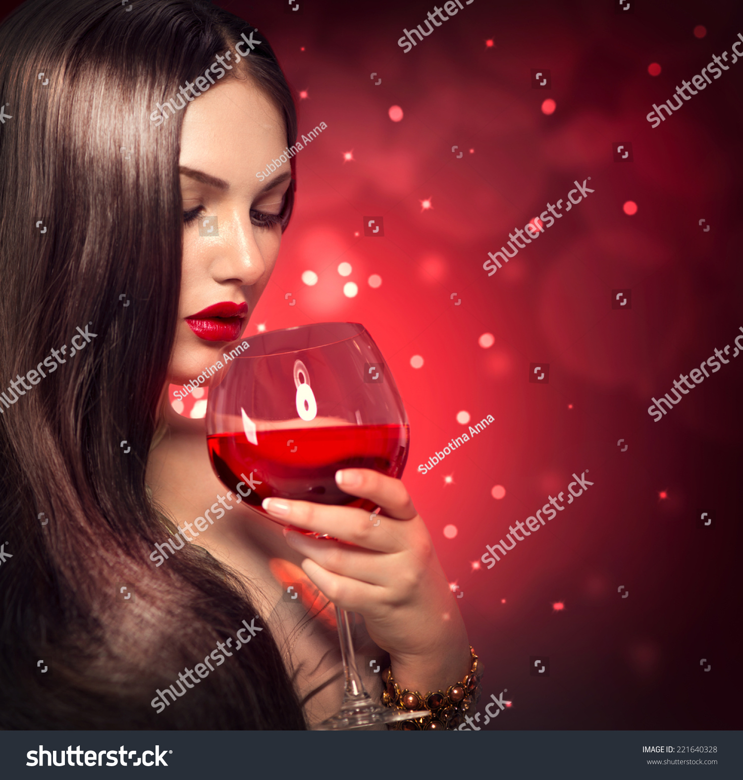 美丽年轻性感的女人喝红酒在假日闪烁背景。美