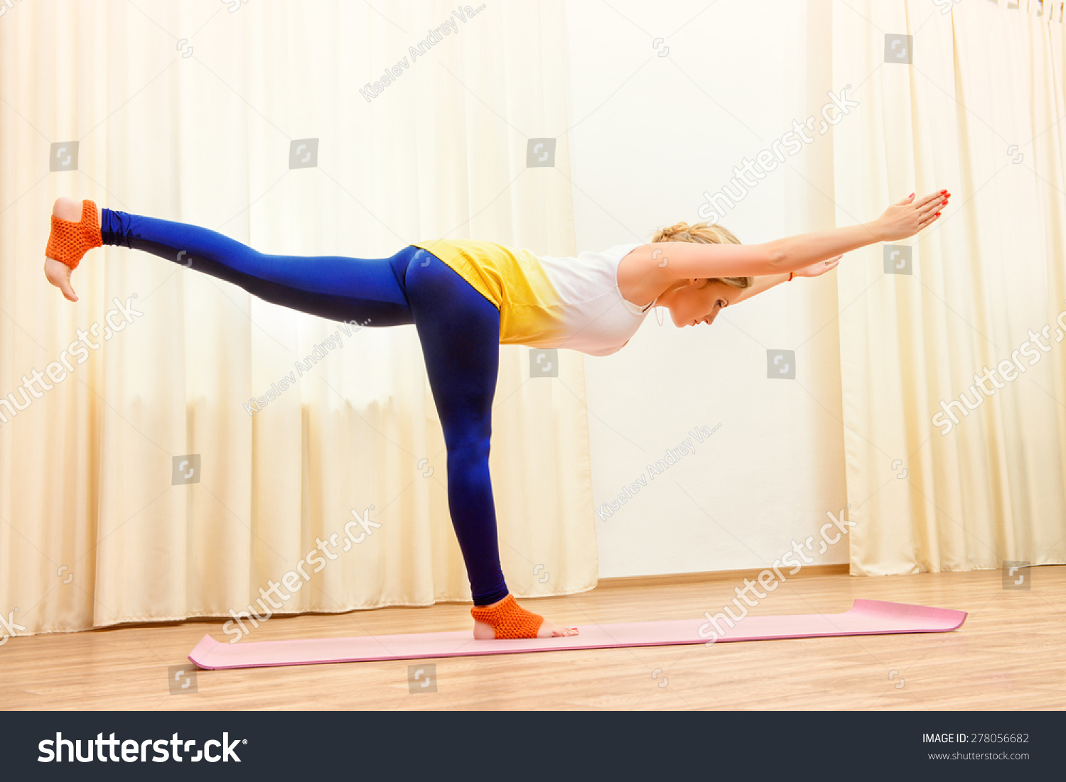 纤细的运动女孩做瑜伽练习室内。专业的教练。