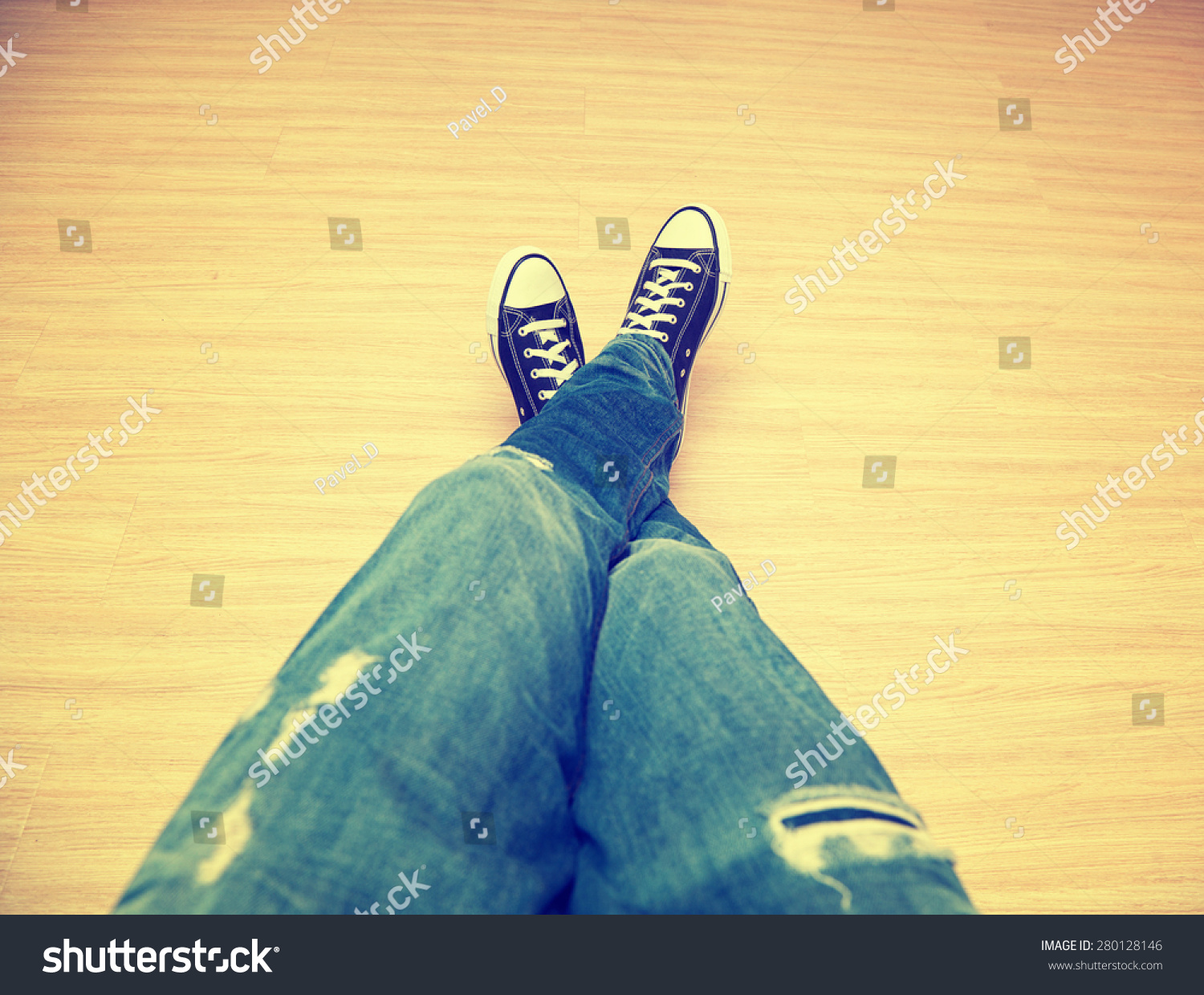 脚经典少年穿着牛仔裤和运动鞋--一个透视图。