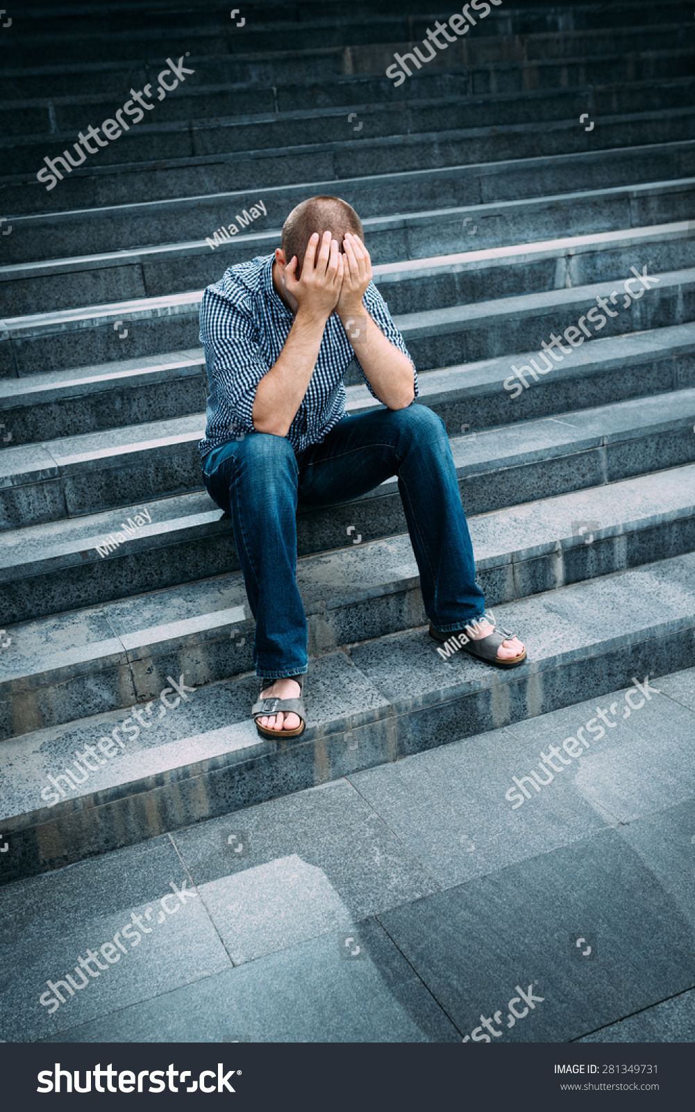户外的画像绝望的年轻人用双手捂着脸坐在楼梯
