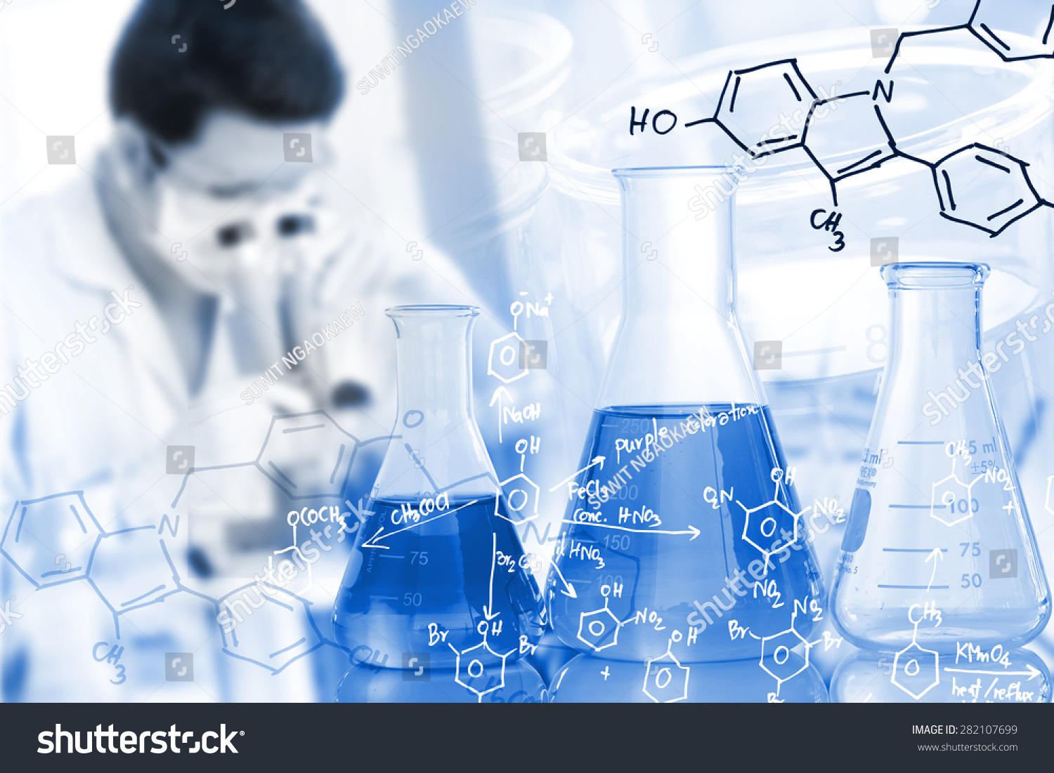 男科学研究人员在实验室使用显微镜和化学方程