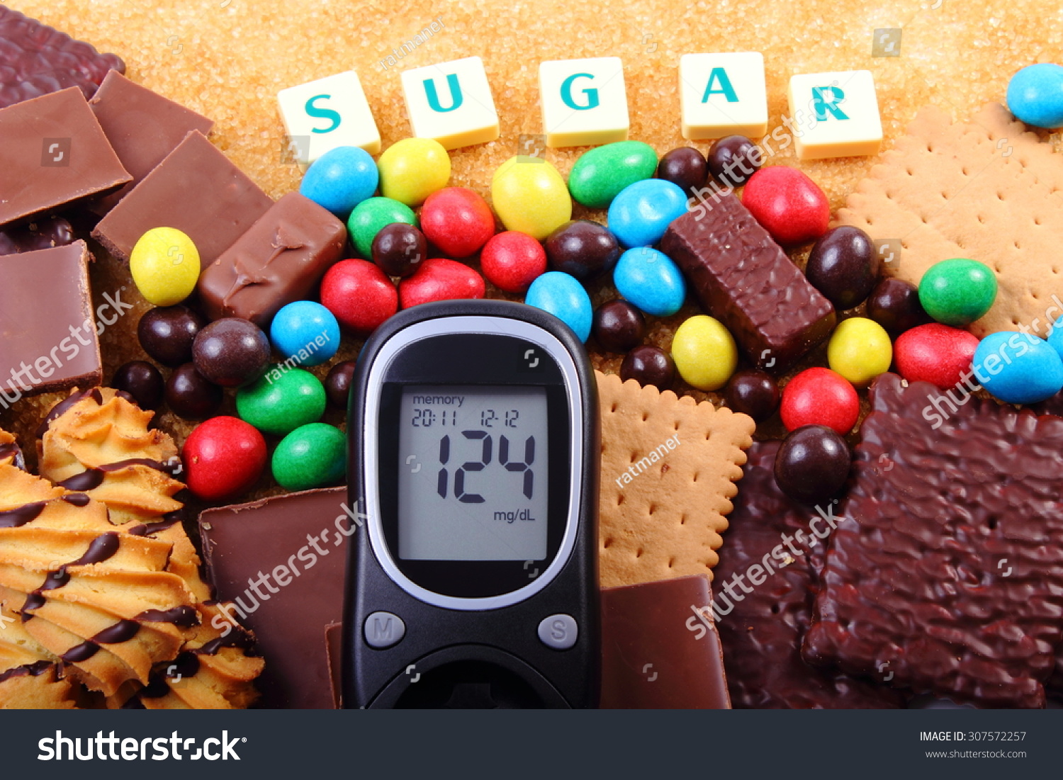 血糖仪与糖,堆糖果、饼干和棕色的蔗糖,太多的