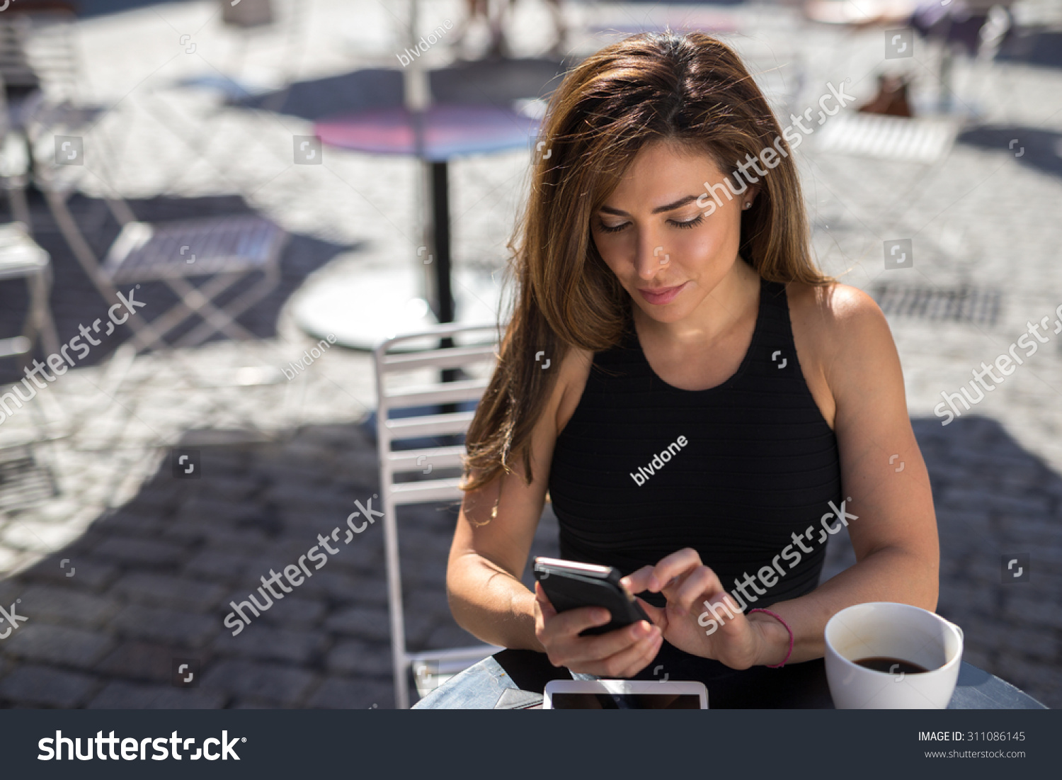 年轻的拉丁裔白人妇女在户外咖啡馆multituskin
