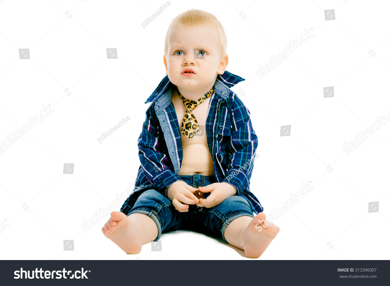 不满意的小男孩在一个格子衬衫,领带和牛仔裤
