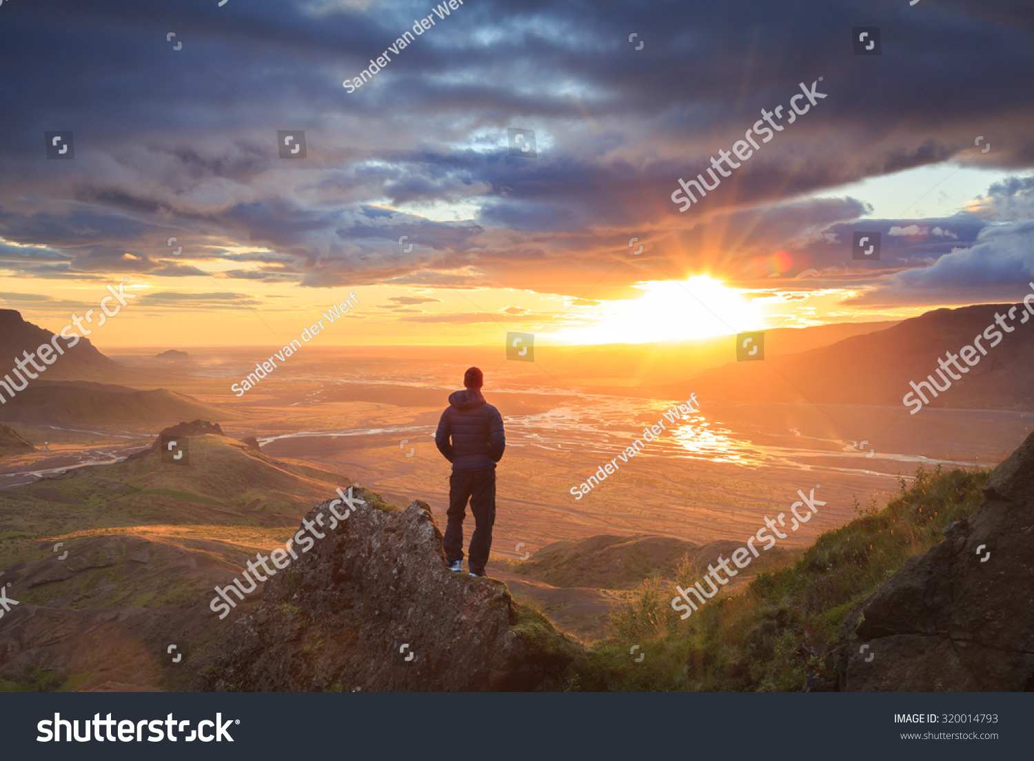 人站在一座山的窗台,享受美丽的落日Thorsmo