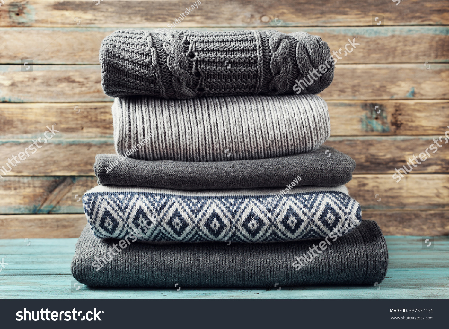 堆针织冬季衣服木制背景、毛衣、针织品、空间
