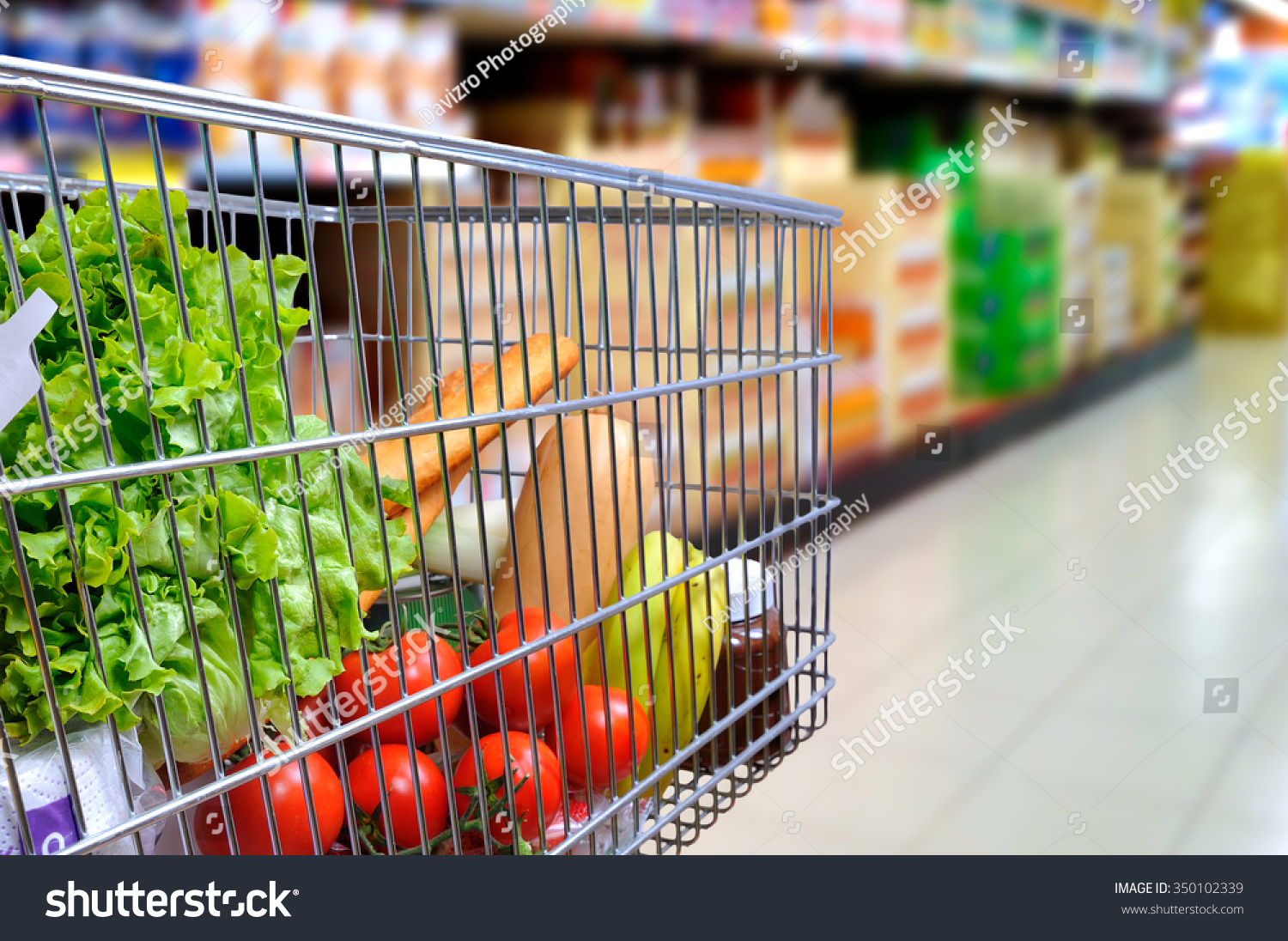 购物车满是食物在超市过道。一边倾斜。水平的