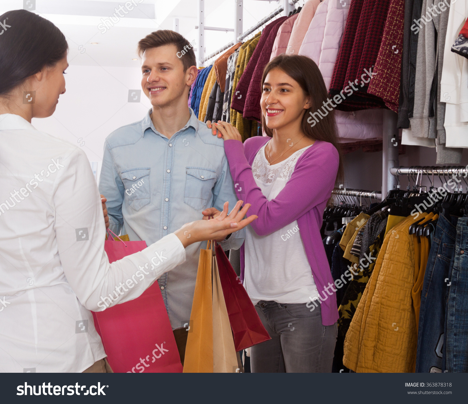 推销员在一个服装店建议一对年轻的夫妇-人物