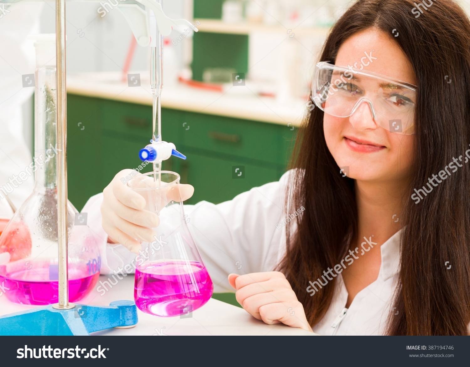 快乐的黑发与化学滴定分析学生在实验室。-工