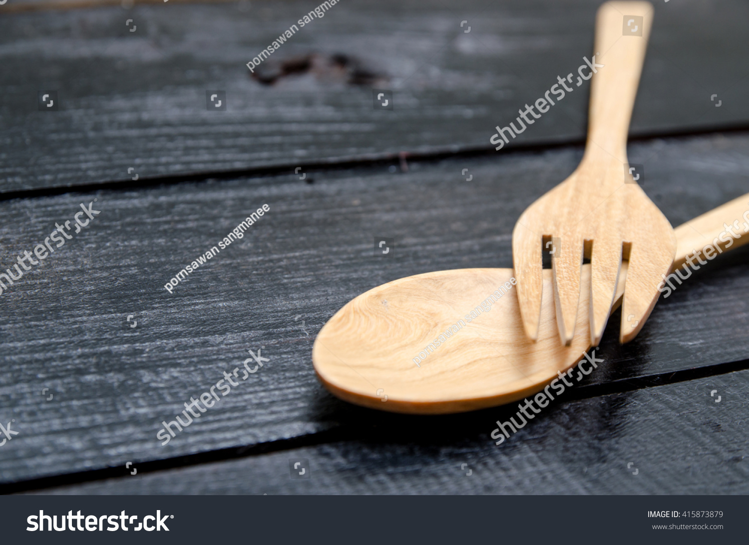 手工制作的木制厨具用叉子和勺子在黑色的木头