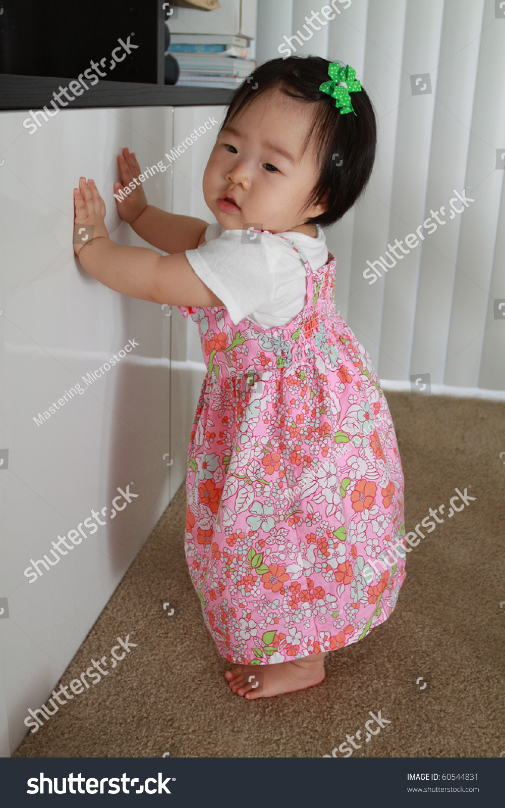美丽的亚洲婴儿十个月大的女婴在粉红色的花裙