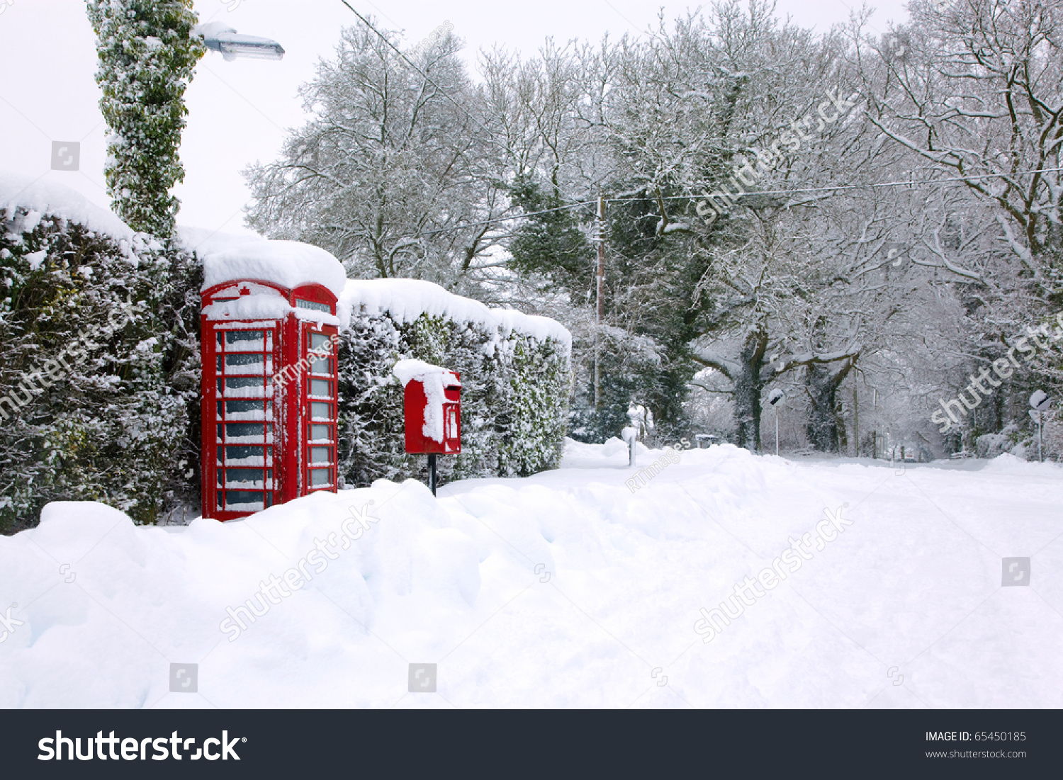 传统的红色英语公用电话和信箱大雪后下降。-