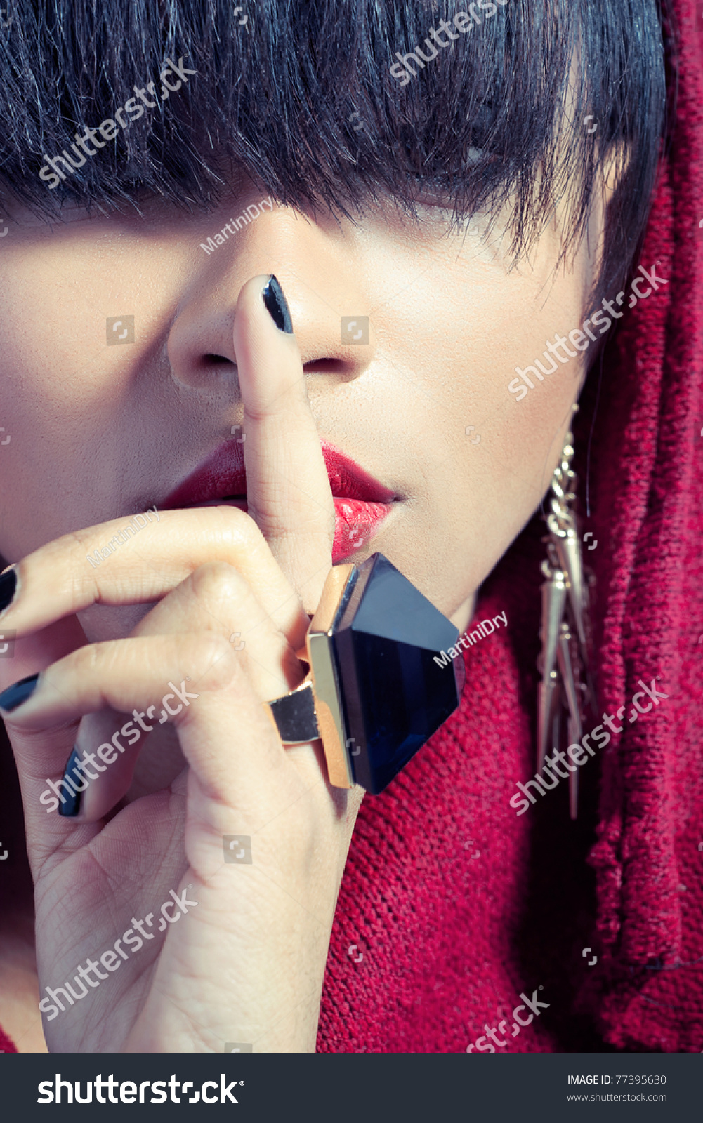 特写的照片年轻女人用手指红嘴唇,信号保持秘