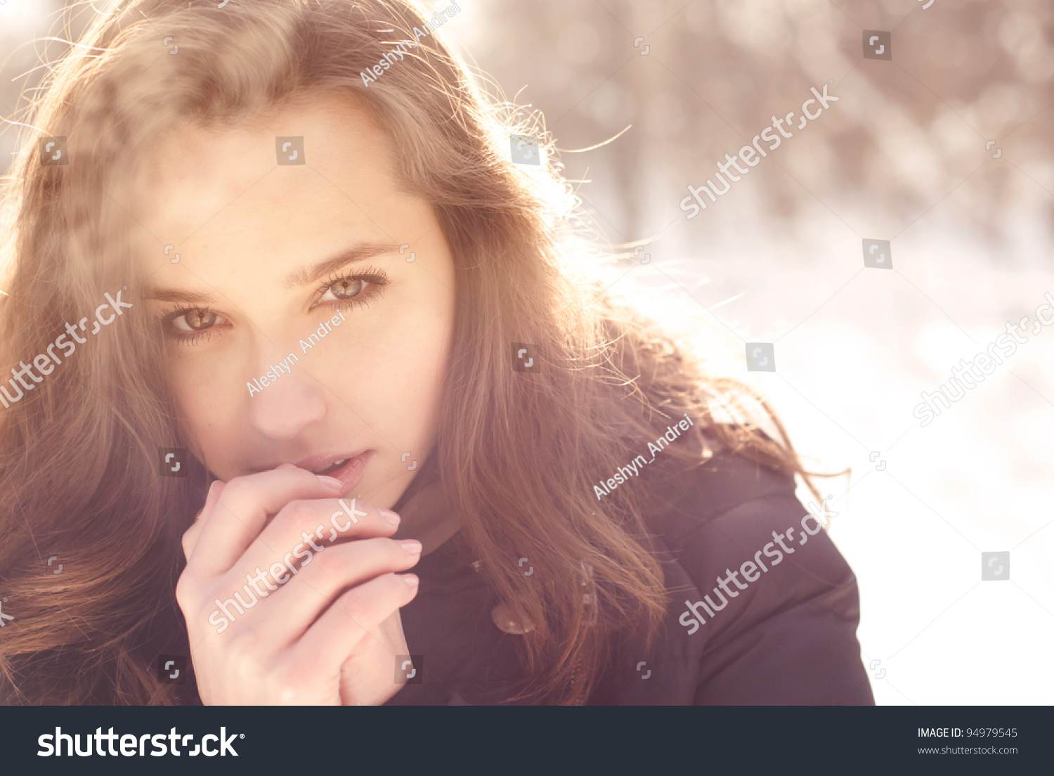 美丽的女孩在冬天冻结公园。照片在温暖的颜色