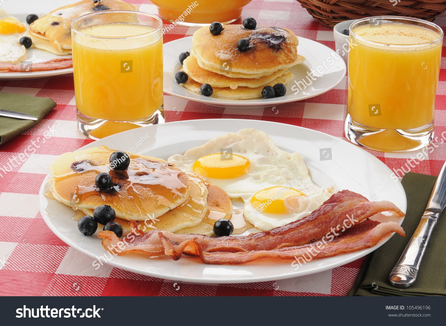 A Breakfast With Bacon And Fried Eggs With Blueberry Pancakes And ...