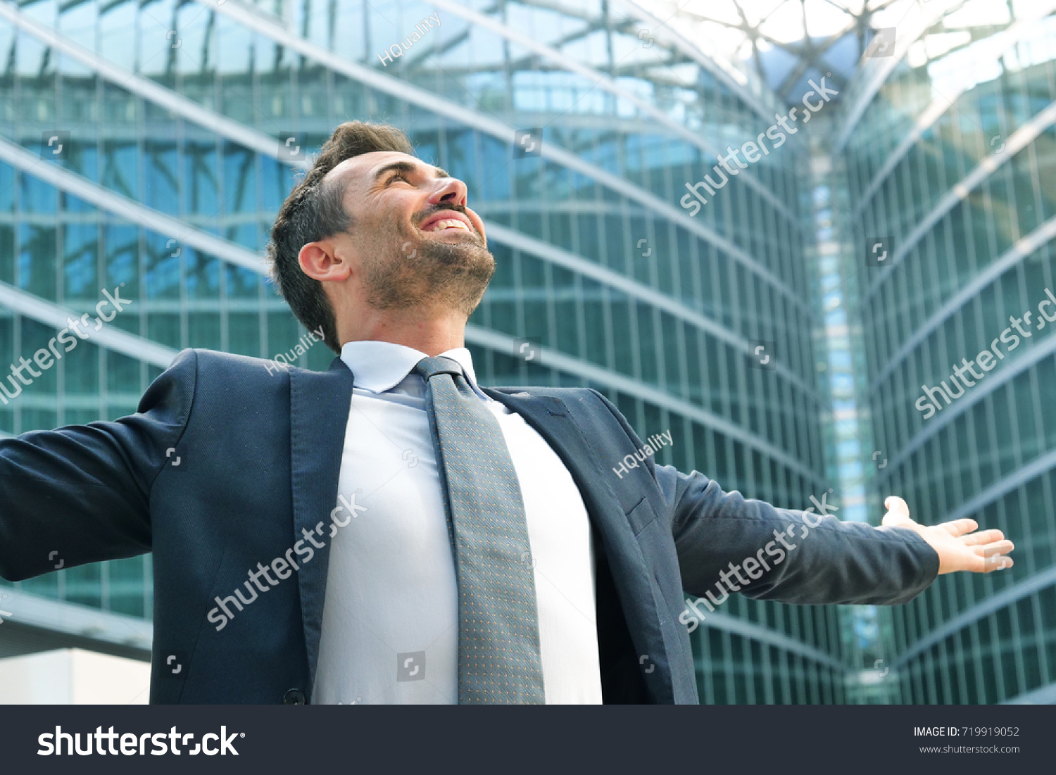 A businessman laughed with open arms and smiling for her success in working in the economic and financial sphere. Concept of: success, exultation, business, freedom.