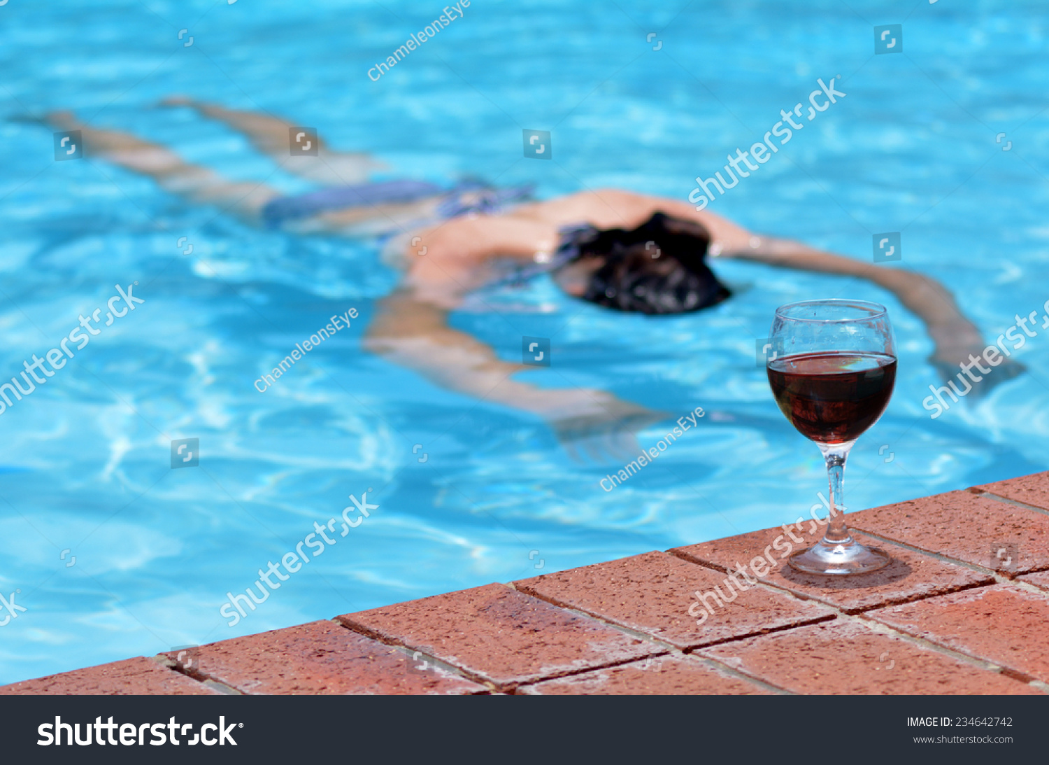 stock-photo-a-cup-of-red-wine-on-a-pool-side-with-drunk-drowning-person-woman-in-a-swimming-pool-at-the-234642742.jpg
