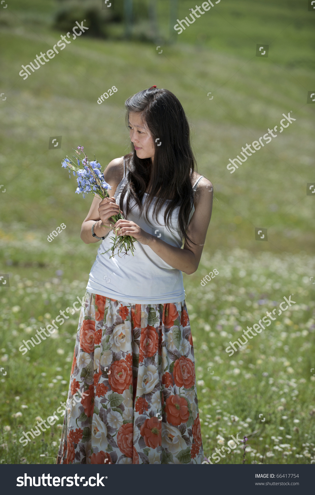 A Girl Gathering Flowers In The Grassland. Stock Photo 66417754 ...