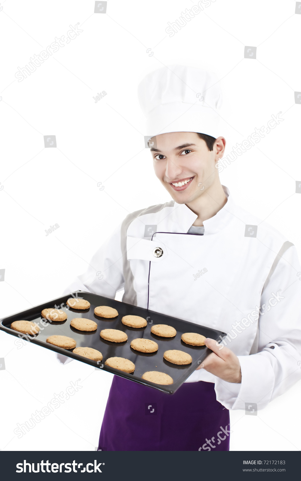 A Handsome Man Chef Holding A Tray Of Cookies Isolated Over White Stock ...