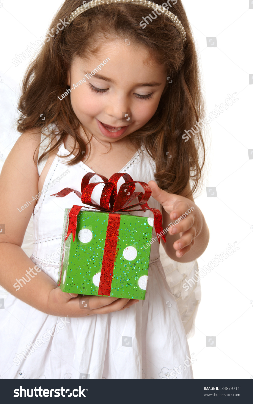 A Little Girl With Brown Hair Looks Down In Delight At A Christmas ...