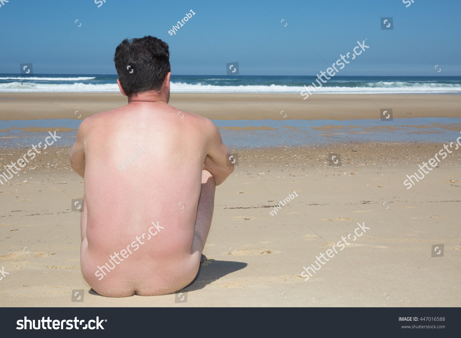 Naked Man Sitting On Empty Beach Shutterstock