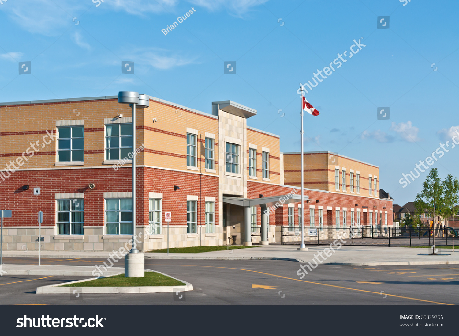 A New Canadian Elementary School Building With Flagpole And Parking Lot ...