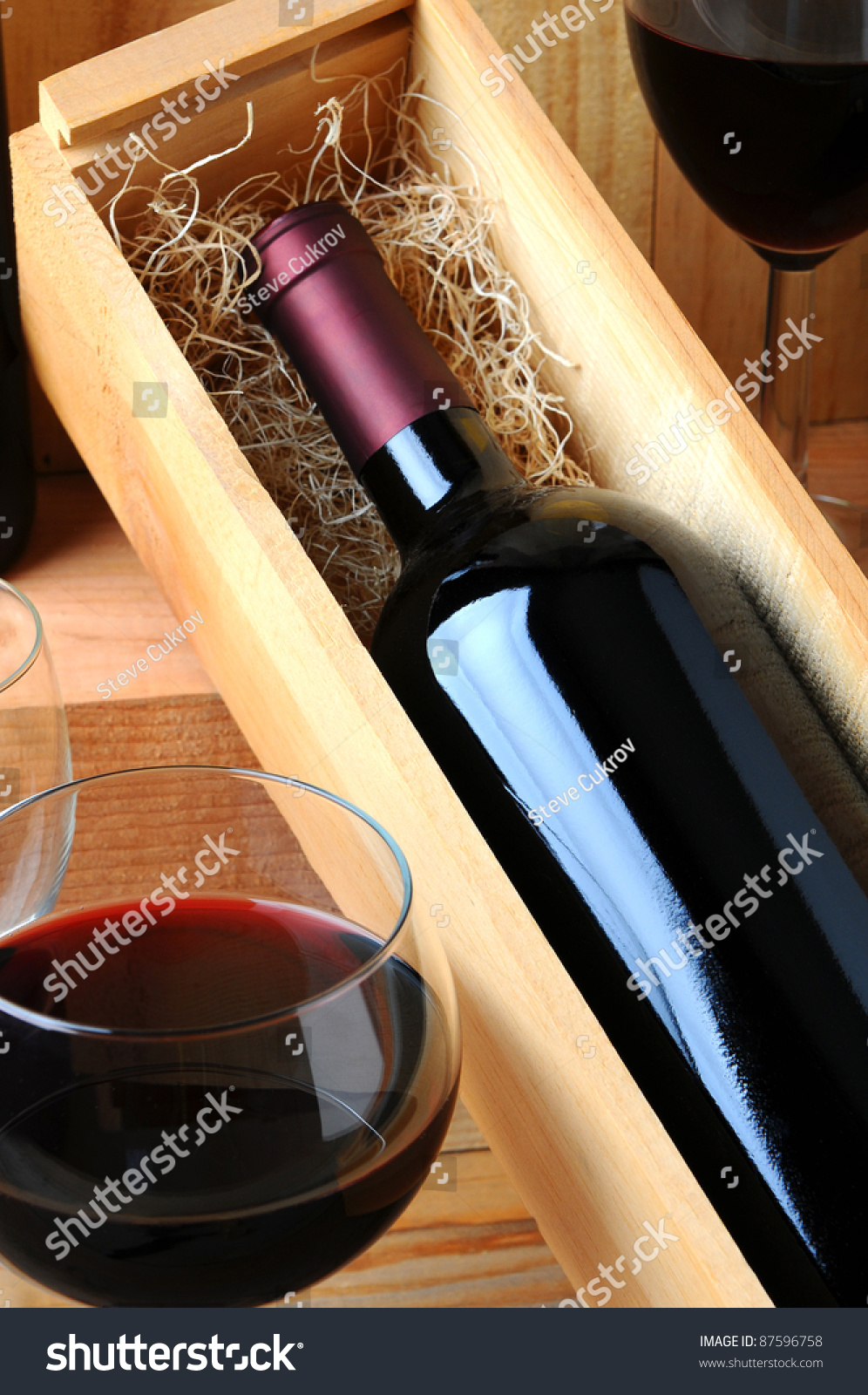 stock-photo-a-red-wine-bottle-in-a-woode