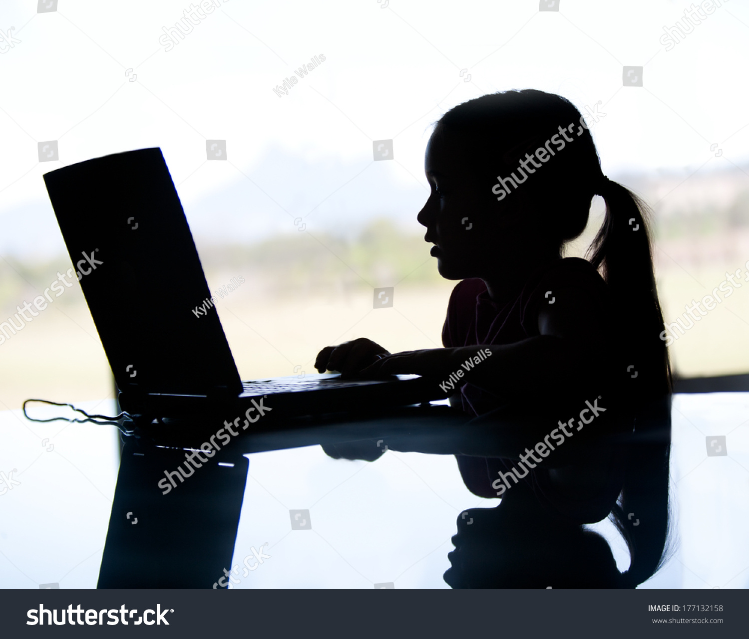 コンピューター上の若い女の子のシルエットが サイバーいじめやインターネットの捕食者によって危険にさらされている可能性があります 彼女は暗がりをしている の写真素材 今すぐ編集