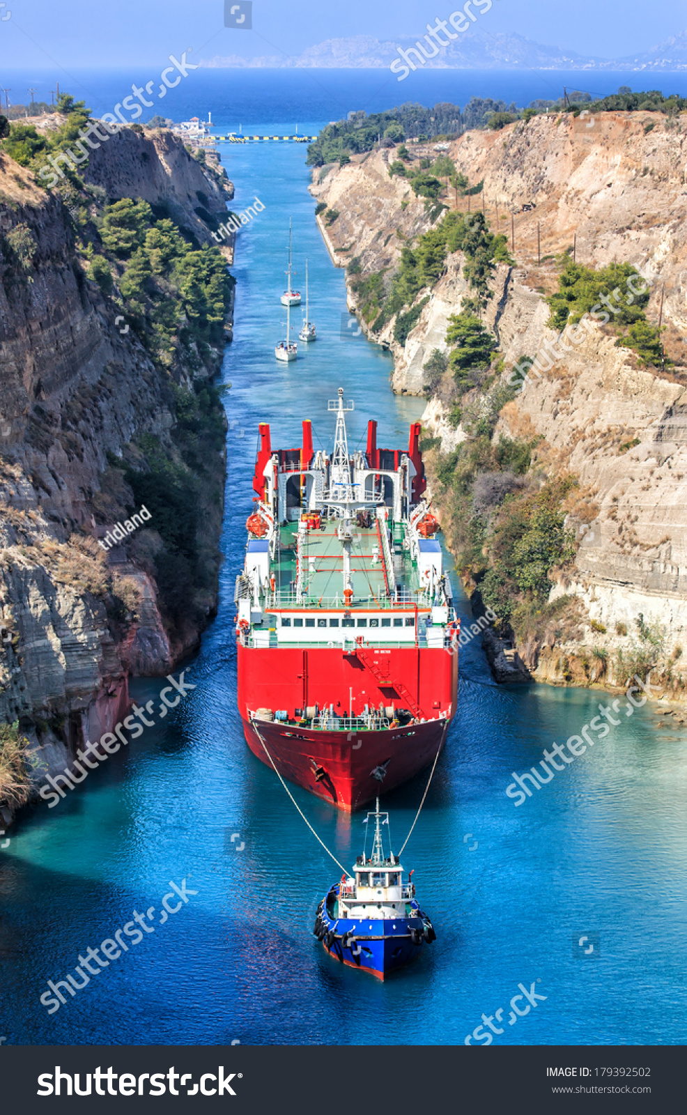 ギリシャのコリント運河を通過する貨物船を引っ張るタグボート の写真素材 今すぐ編集