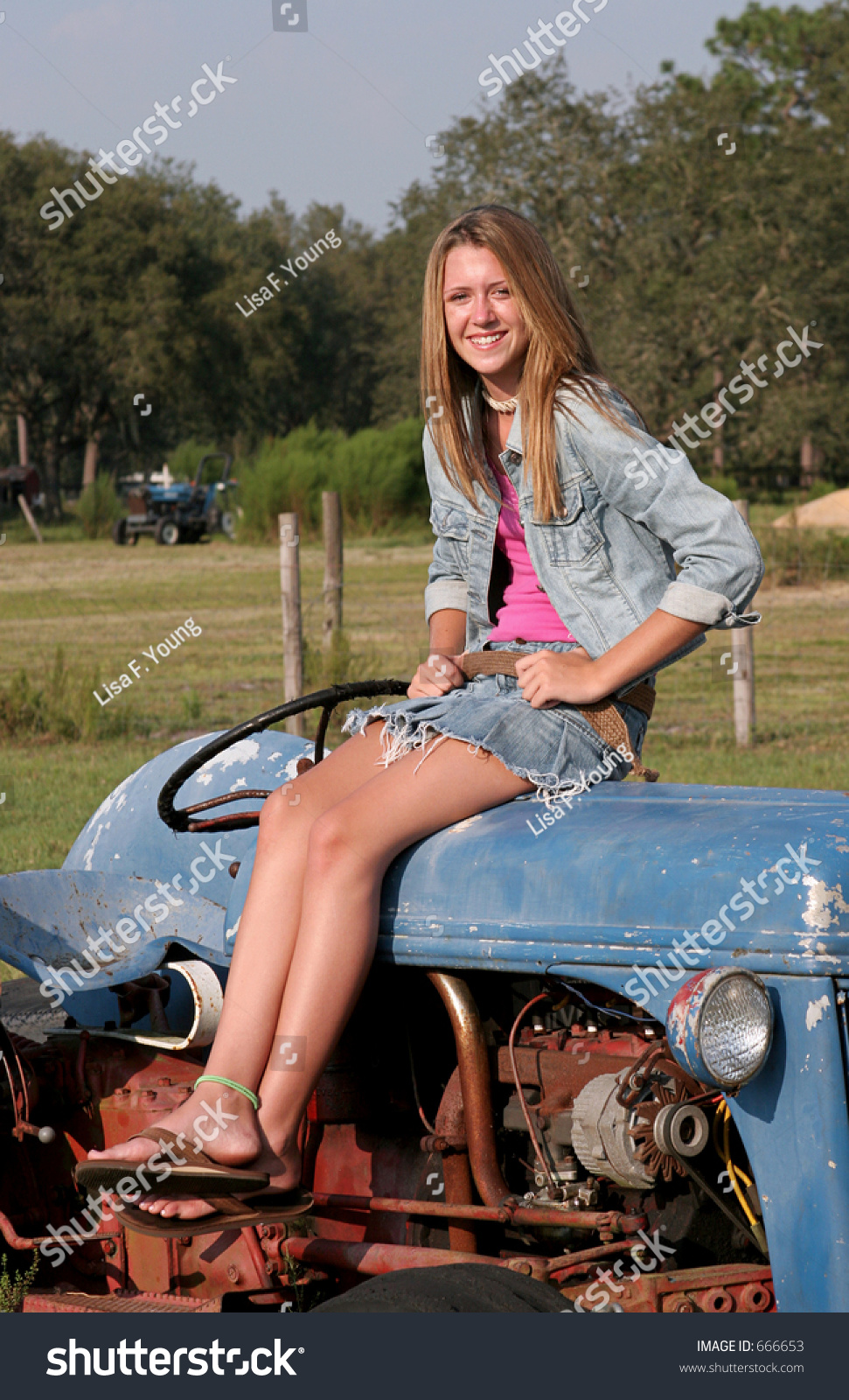 A Vertical View Of A Farmer'S Daughter Sitting On A Tractor. Stock ...