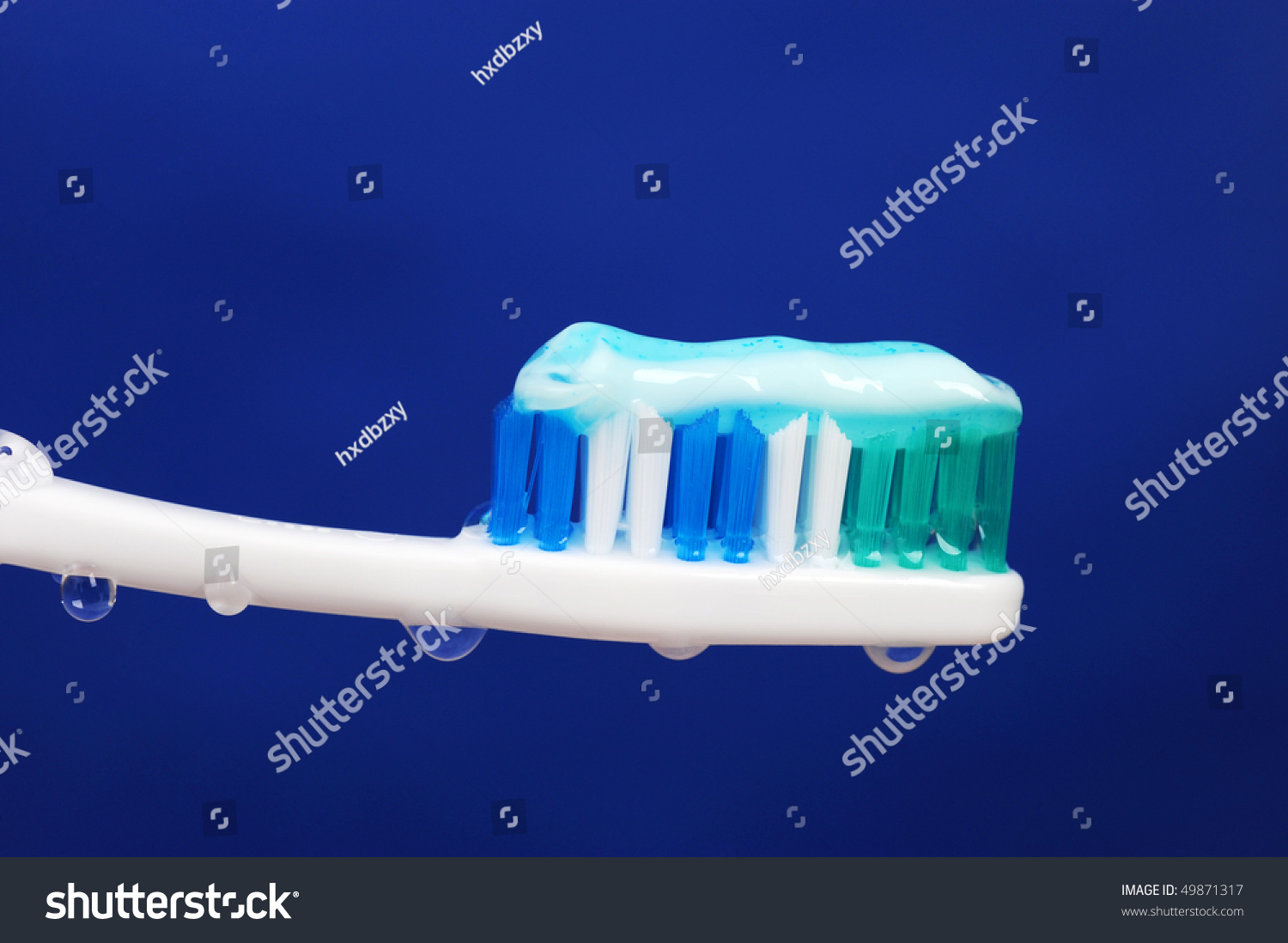 A Wet Toothbrush With Some Toothpaste On It, And Drops Of Water Over ...