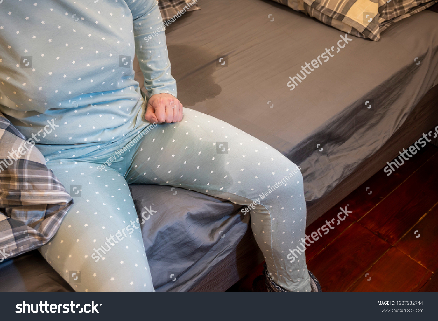 ベッドの端には、濡れたパジャマを着た女性が座る。 グレーシートの濡れた染み。 失禁。 夜間性利尿による排尿行為の制御不能。 コンセプト。写真素材1937932744 Shutterstock