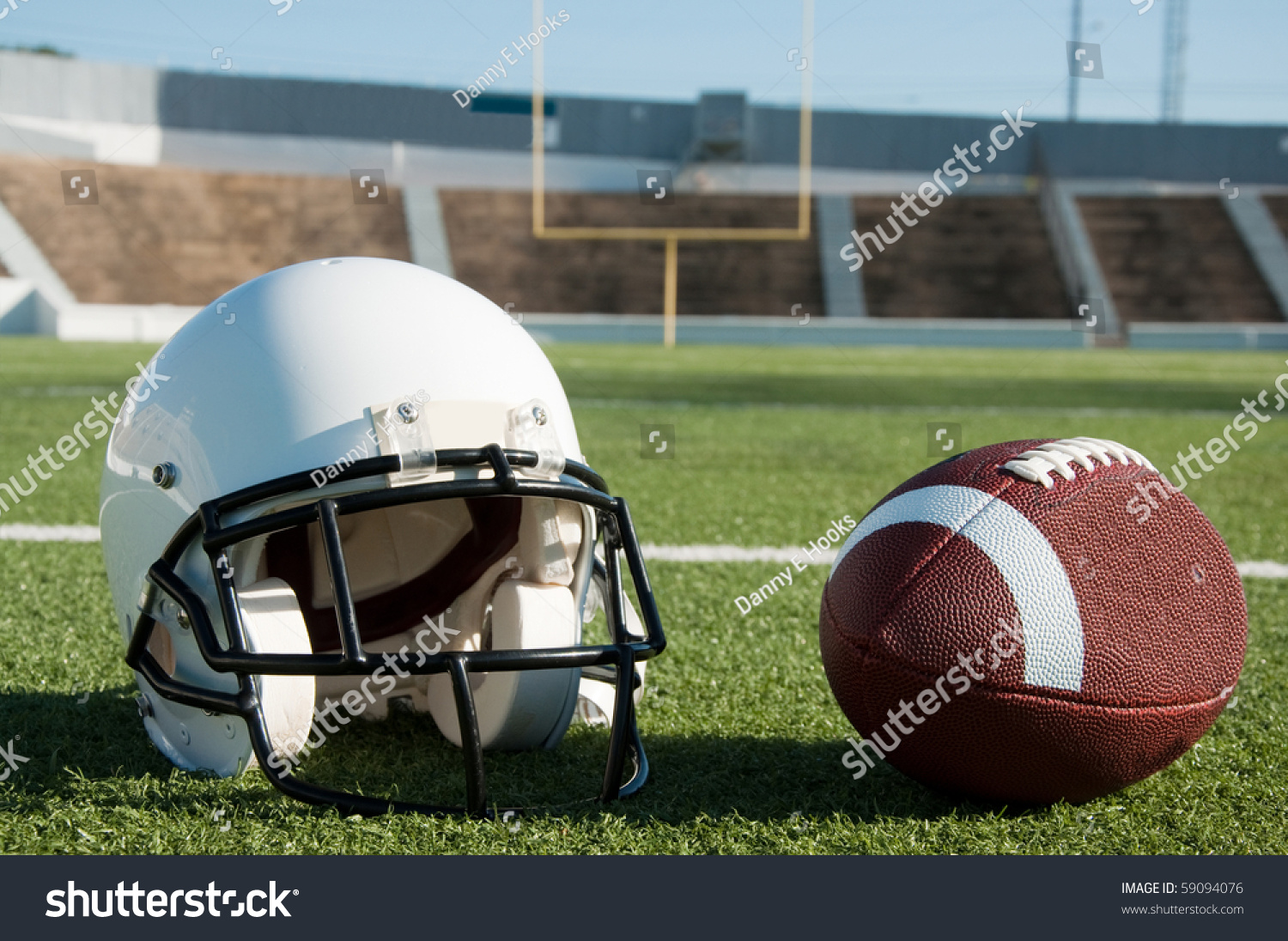 American Football And Helmet On Field With Goal Post In ...