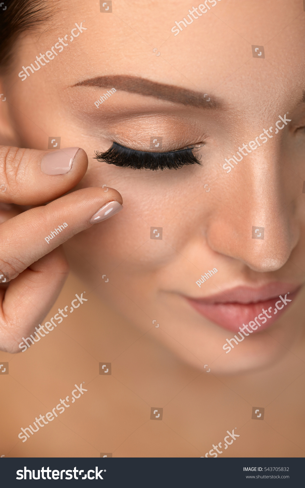 applying false eyelashes