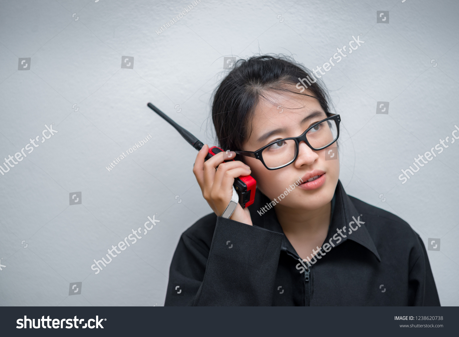 Asian engineer woman wearing glasses,using radio communication on white background,thailand technician use walkie talkie for work