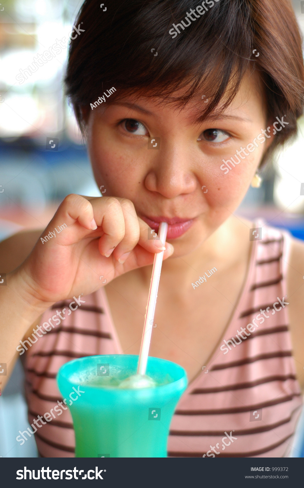 Asian Lady Drinking Iced Coffee From A Straw Asian Lady Drinking Iced Coffee From A Straw