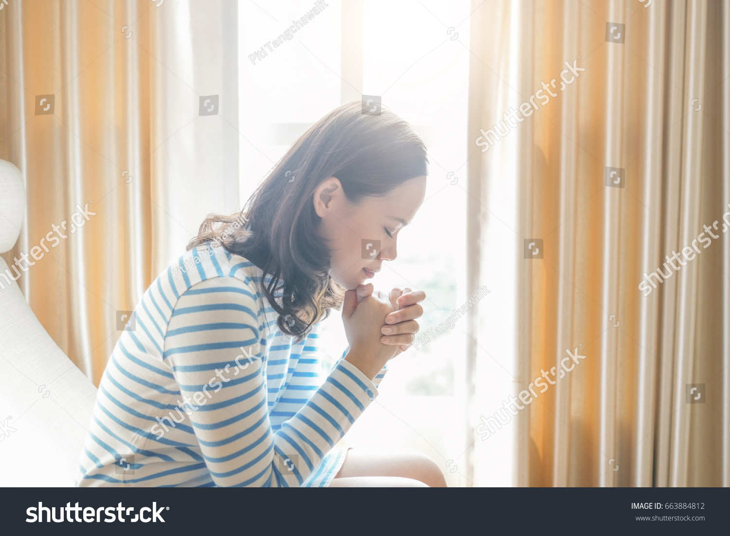 部屋の窓の近くで朝を祈るアジア人の女性 信仰 霊性 宗教のための祈りのコンセプトで手を組む の写真素材 今すぐ編集