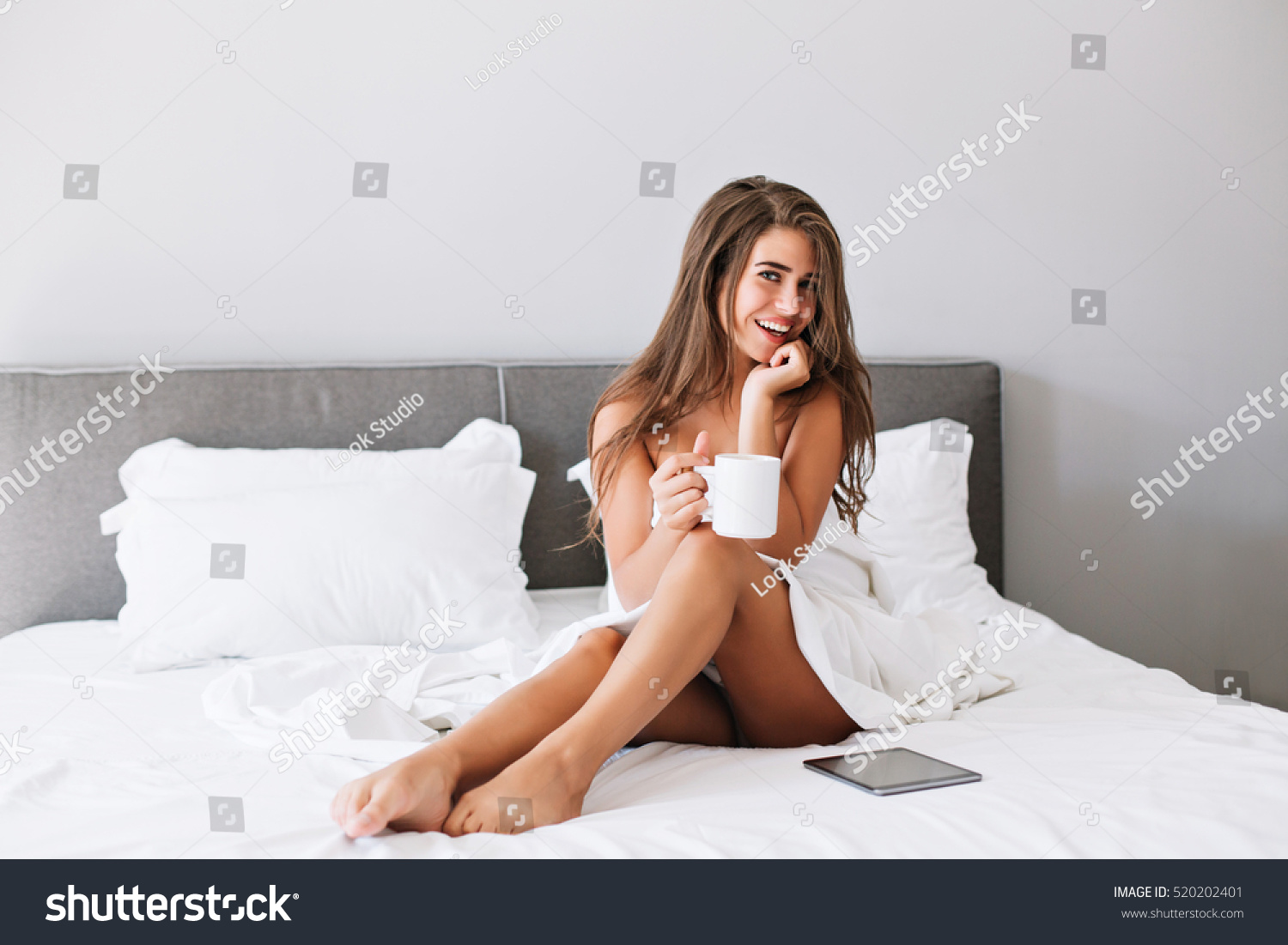 Attractive Girl With Naughty Shoulders And Legs Drinking Coffee On Bed In The Morning In Modern Attractive Girl With Naughty Shoulders And Legs Drinking Coffee On Bed In The Morning In Modern