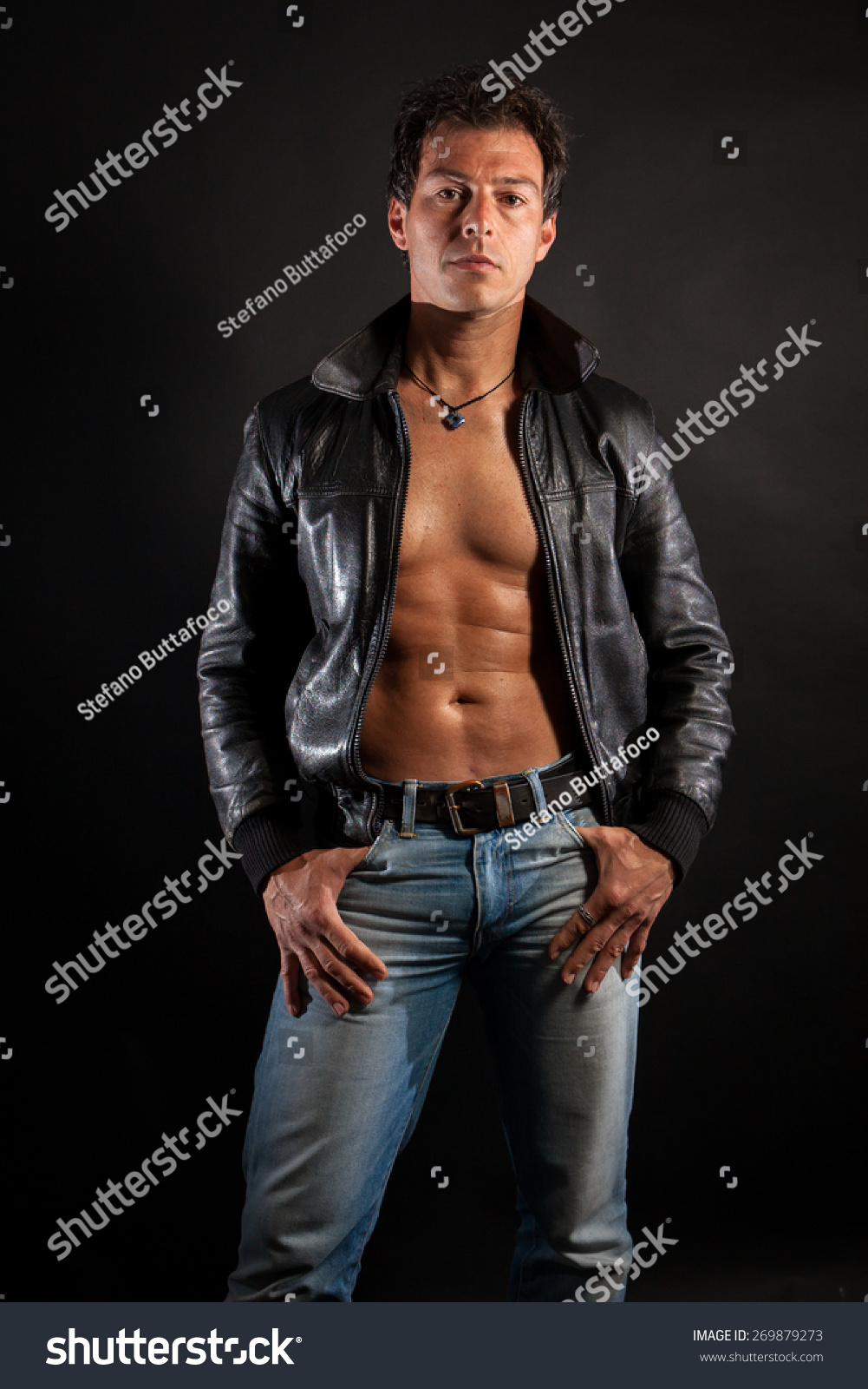 Attractive Man In Leather Jacket And Jeans Posing Shirtless In Studio ...