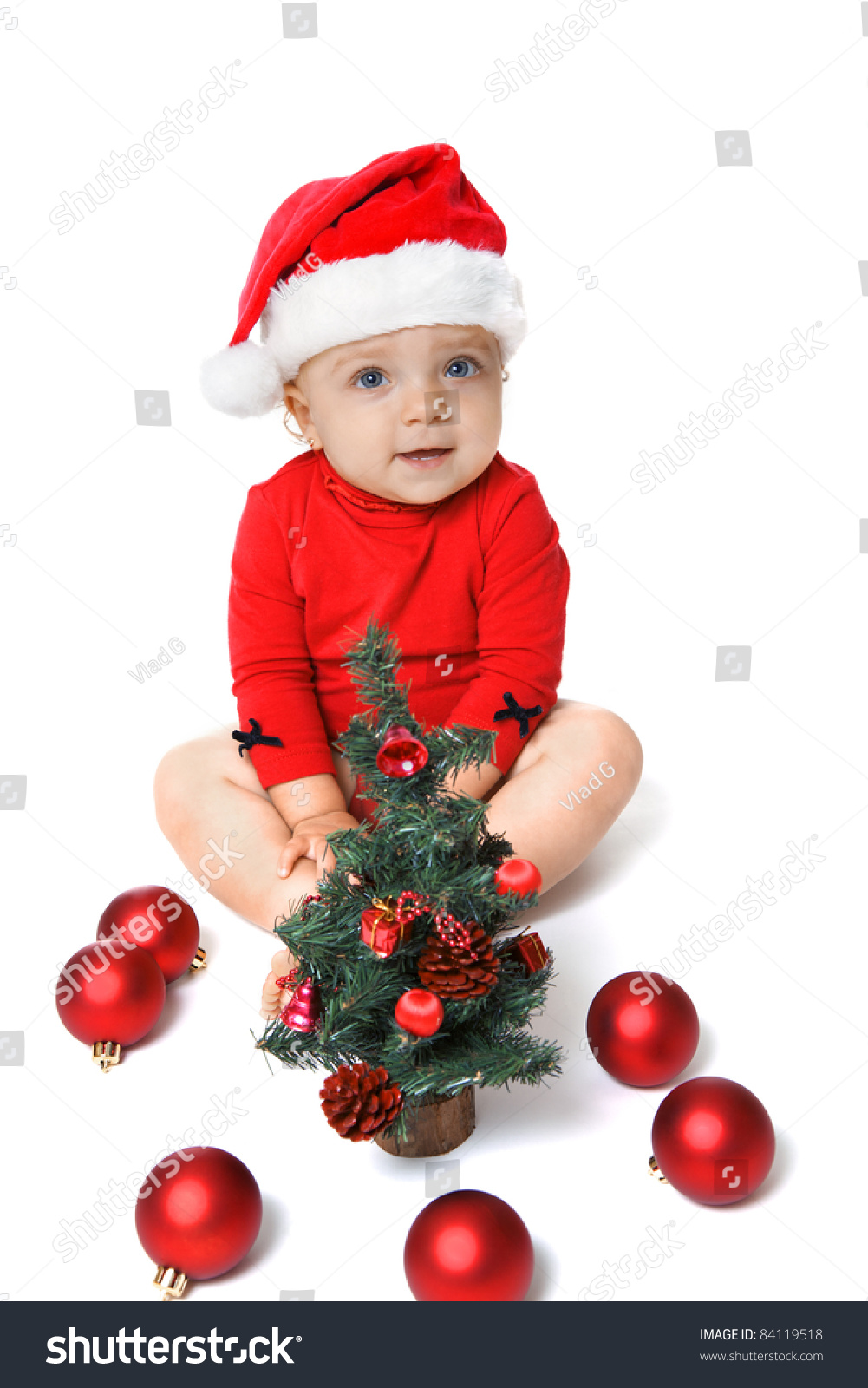 Baby Girl Wearing A Santa Claus Hat, Playing With Red Balls, Near The ...
