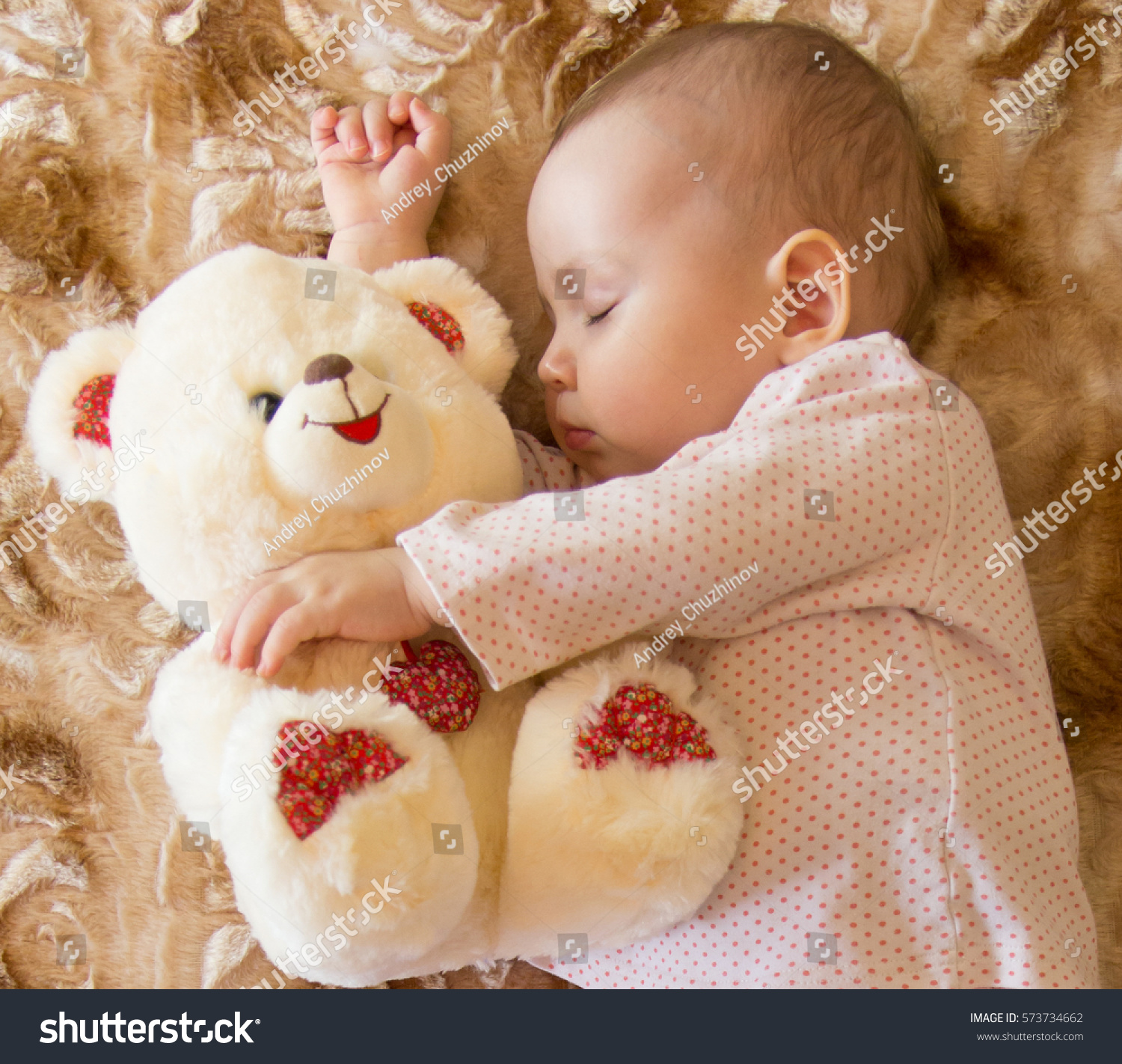 baby hugging teddy bear