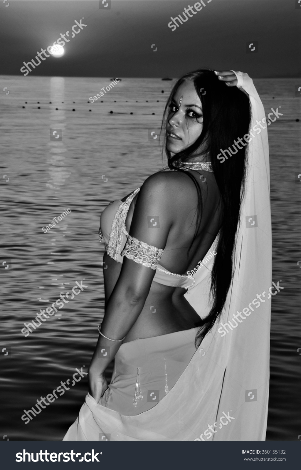 Beautiful black and white image of a gorgeous girl in belly dance costume with veil posing