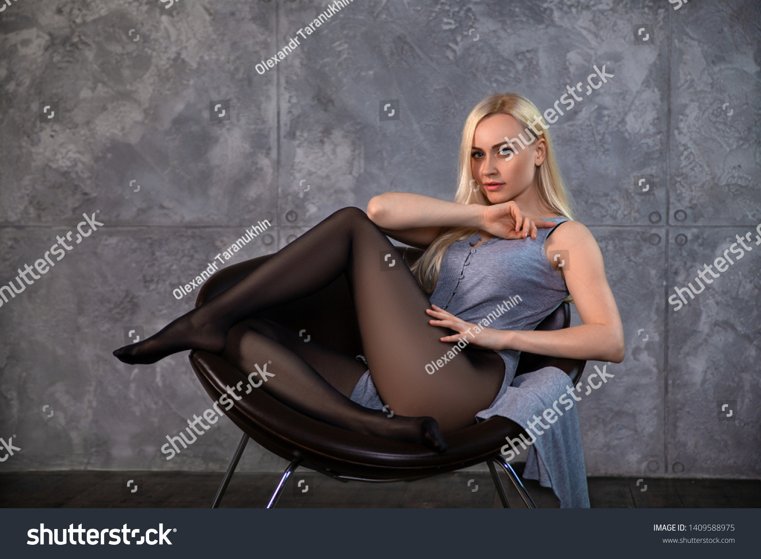美しい金髪娘で 椅子にポーズをつけたパンティホースに完璧な脚を持つ 美しいグラマーのポートレート の写真素材 今すぐ編集
