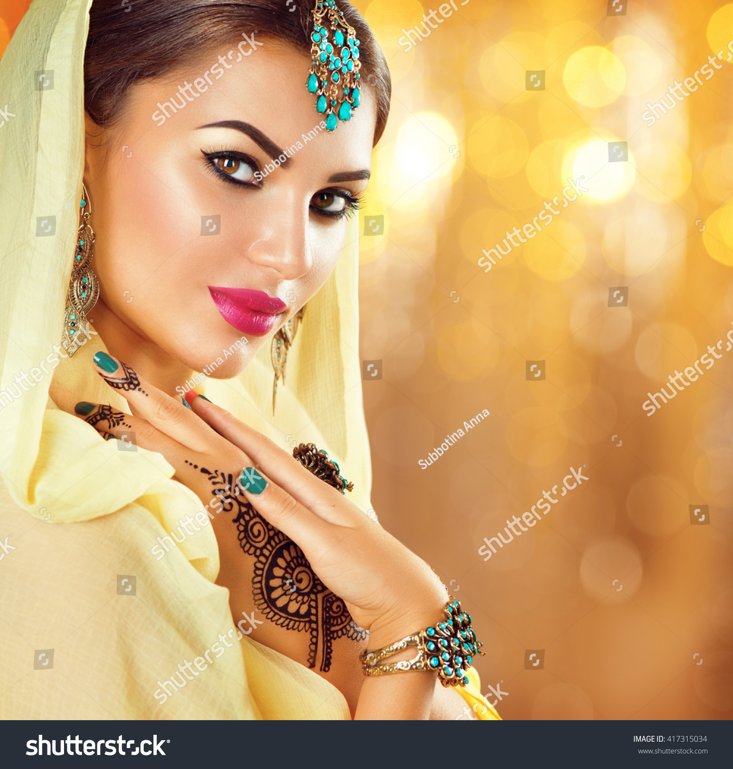 東洋のアクセサリーを持つ美しいファッション・インドの女性のポートレート イヤリング、ブレスレット、リング。黒いヘナの入れ墨と美しい宝石を